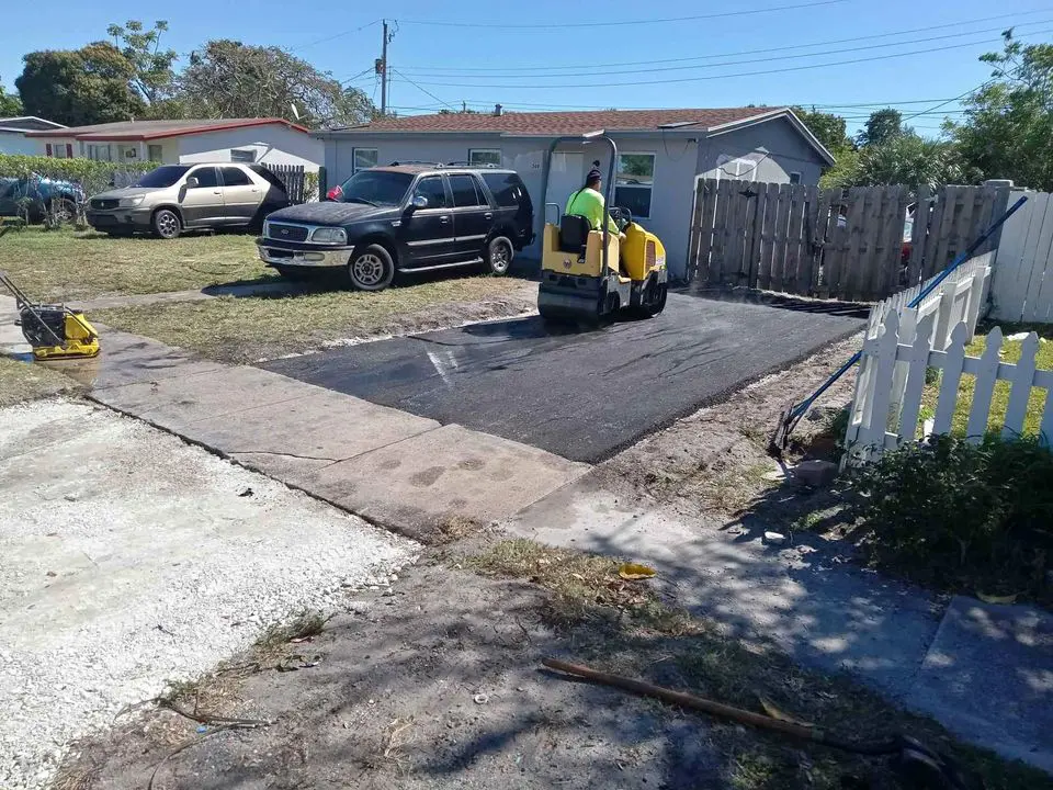 small single family home asphalt driveway being compacted after just being laid by SoFlo Asphalt