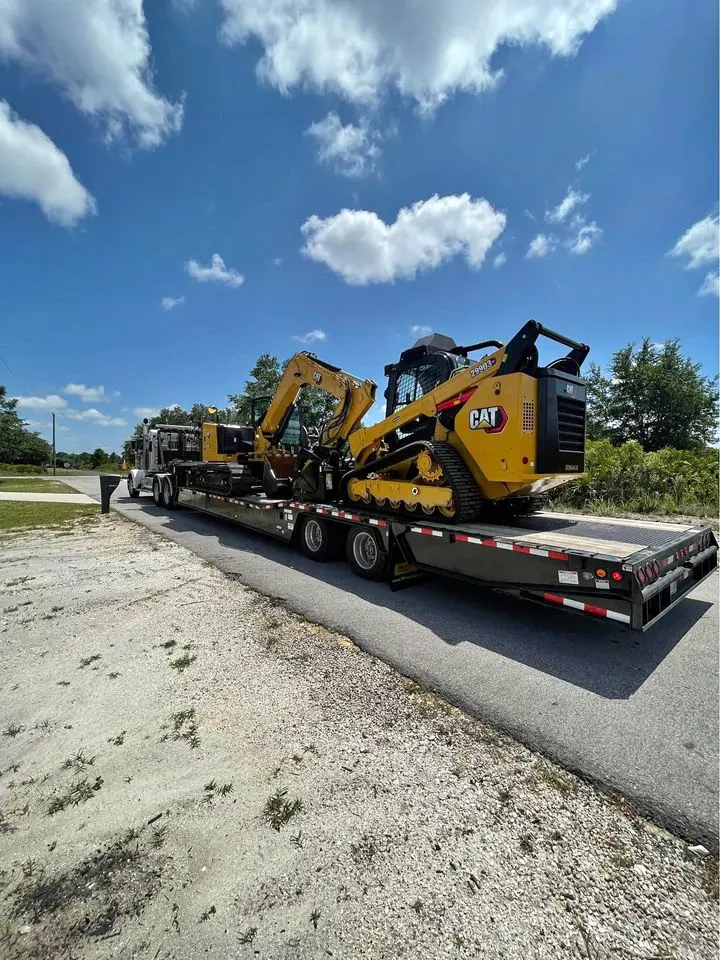 asphalt paving machine and excavator on the back of a large truck, ready to go to work paving a new asphalt road