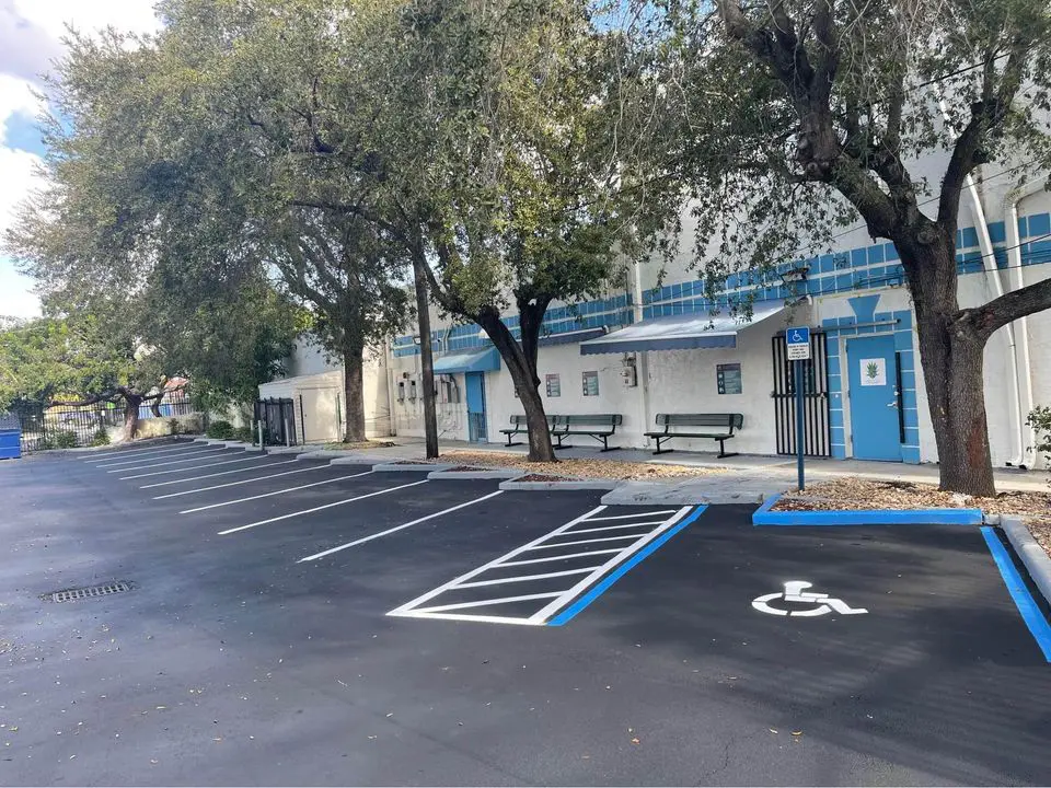 Parking lot sealed with ADA approved lines and spaces highlighted in blue against the freshly sealed black asphalt