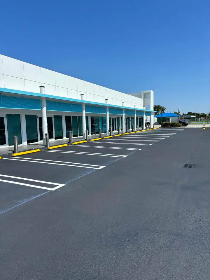 parking lot at shopping mall in boca raton sealed with hot asphalt sealer then line striped performed with white parking lines and yellow wheel stops