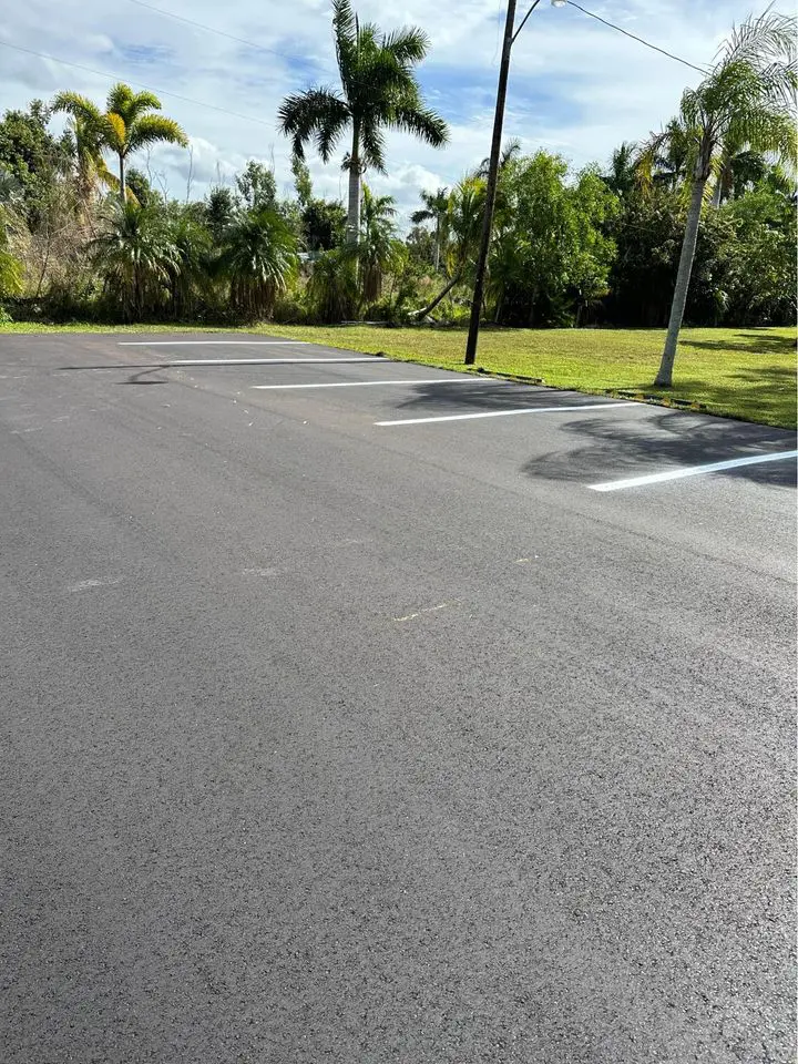 Newly paved asphalt parking lot with freshly painted lines for 6 parking spots